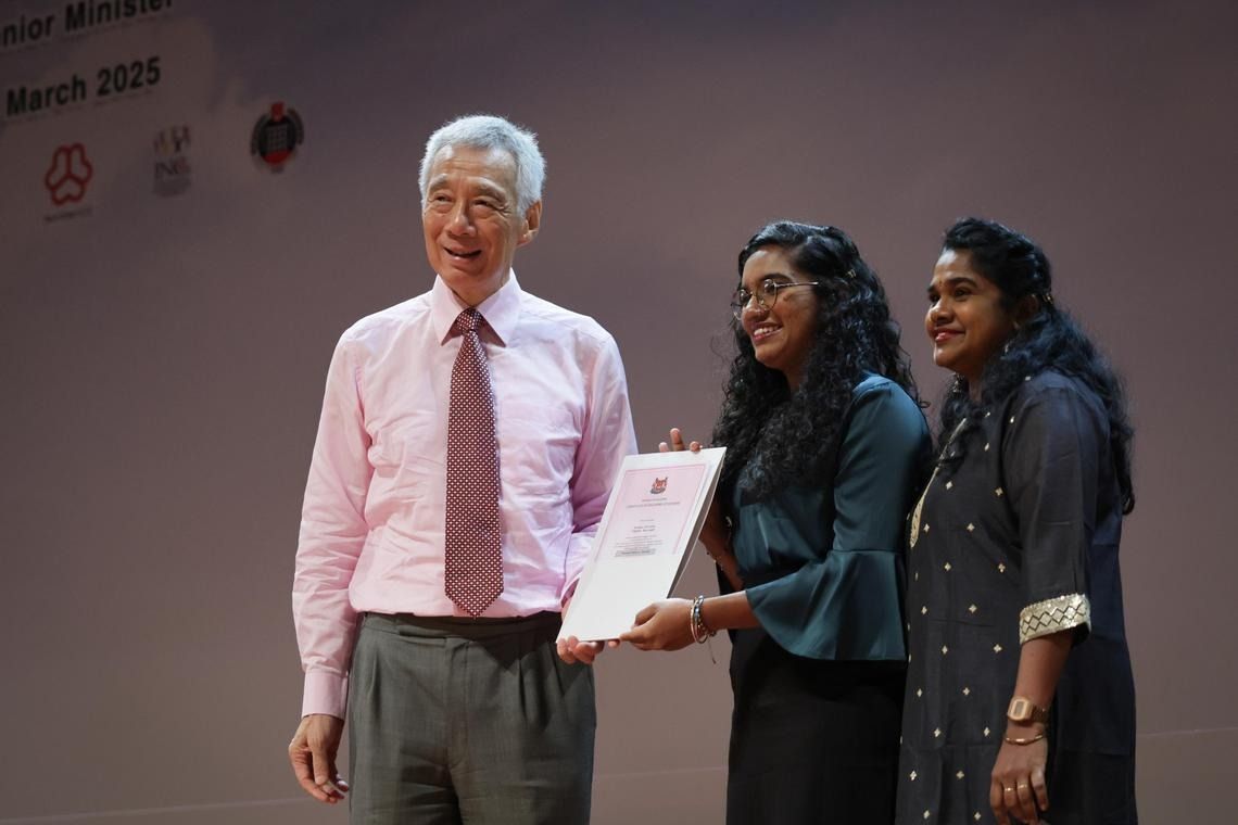 Senior Minister Lee Hsien Loong presenting the citizenship certificate to Prithikka Divyashini during the Teck Ghee Citizenship Ceremony. With her is her mother, Madam Deivanai Subbarayan, a Singapore PR. -- ST PHOTO: GIN TAY