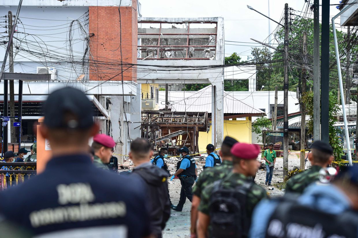 Thailand's forensic police officers (centre) inspect the site of an attack that killed two defence volunteers and injured 12 others, outside the district office of Sungai Kolok in the southern Thailand province of Narathiwat on Sunday, March 9, 2025. A low-level conflict has simmered in the country's southernmost provinces since 2004, killing more than 7,000 people, as rebels in the Muslim-majority region battle for greater autonomy from the state. -- Photo by Madaree TOHLALA / AFP