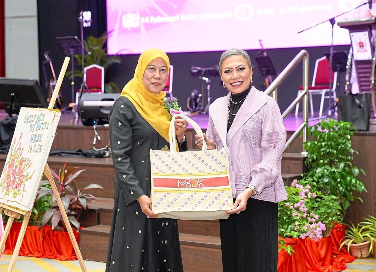 Jamaliah (left) presenting a token of appreciation to Sharifah Shawati. 