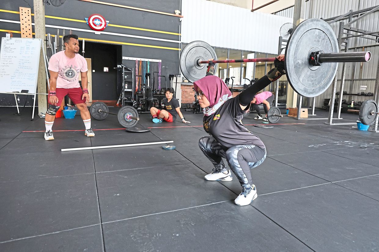 Mohd Azhari (left) coaching a client at his gym in Petaling Jaya.