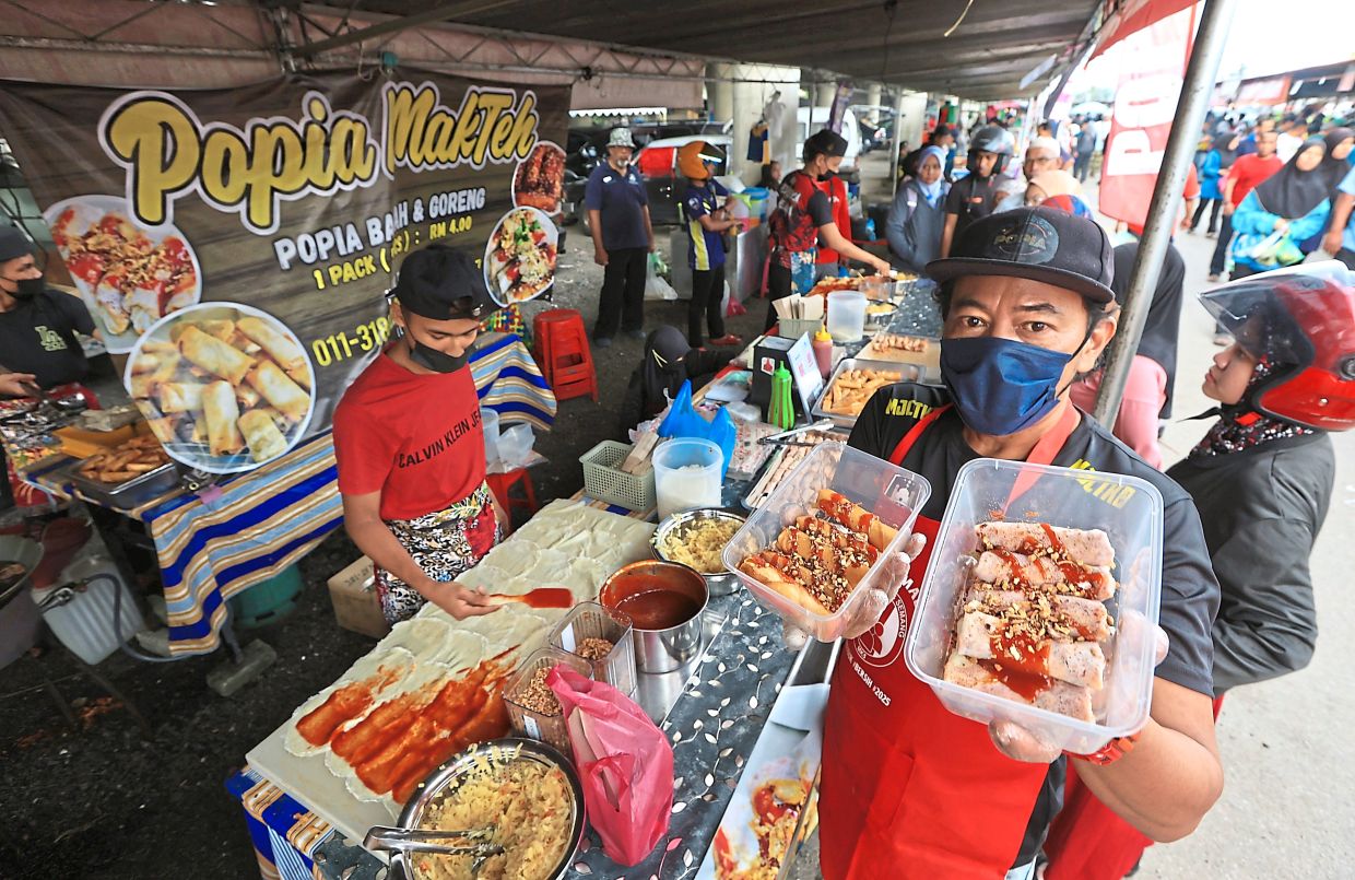 Hamizali (foreground) showing fresh and fried spring rolls which are popular during Ramadan. He sells more than 3,000 pieces of ‘popiah’ on average daily during the fasting month.