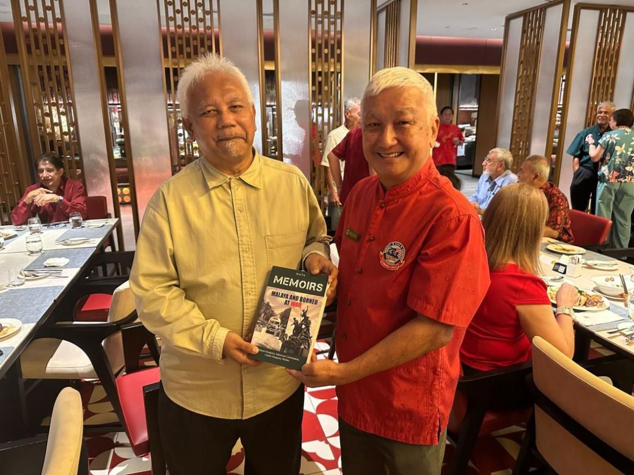 Macva president Datuk Captain Lee Kwang Lock (right) presenting the columnist with the association's second book, 'Memoirs Of the Armed Forces Veterans 2: Malaya and Borneo at War'.