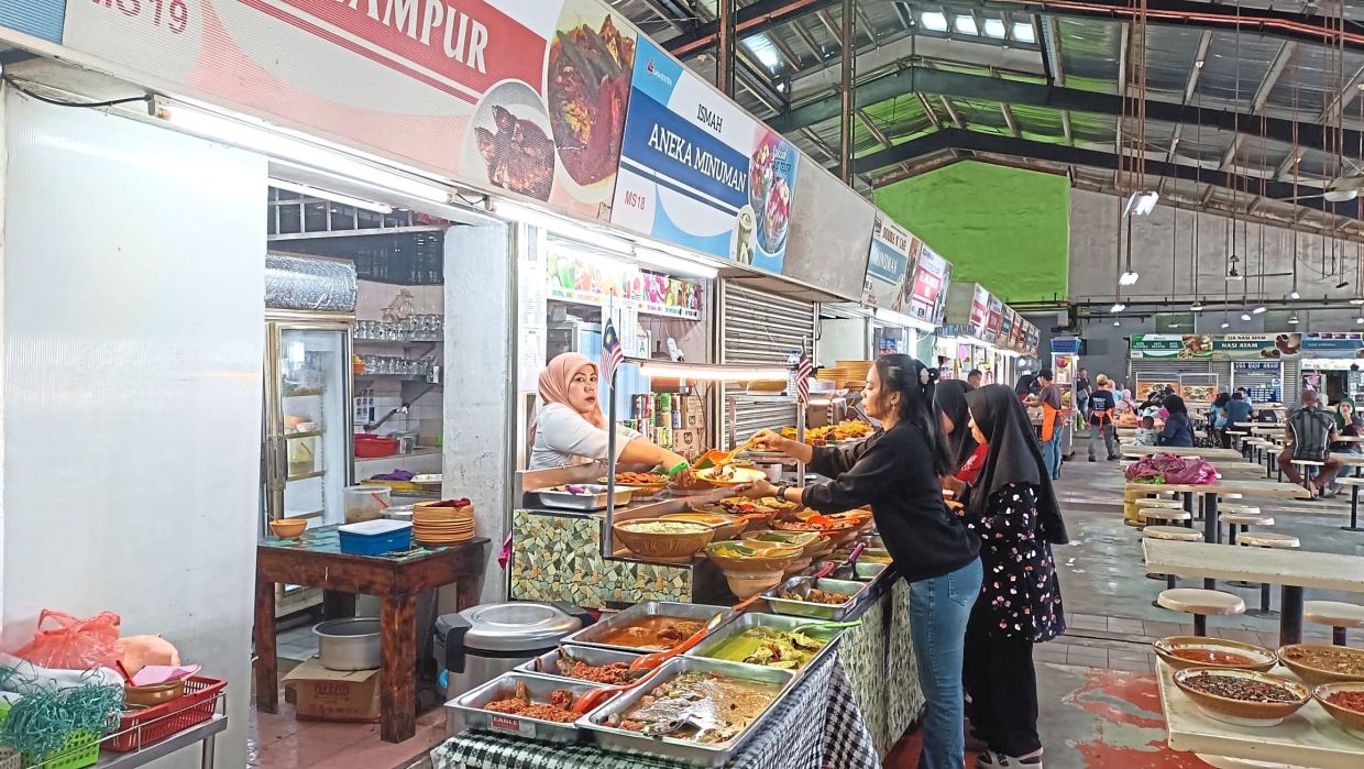 Customers picking their dishes at a mixed rice stall in Larkin.