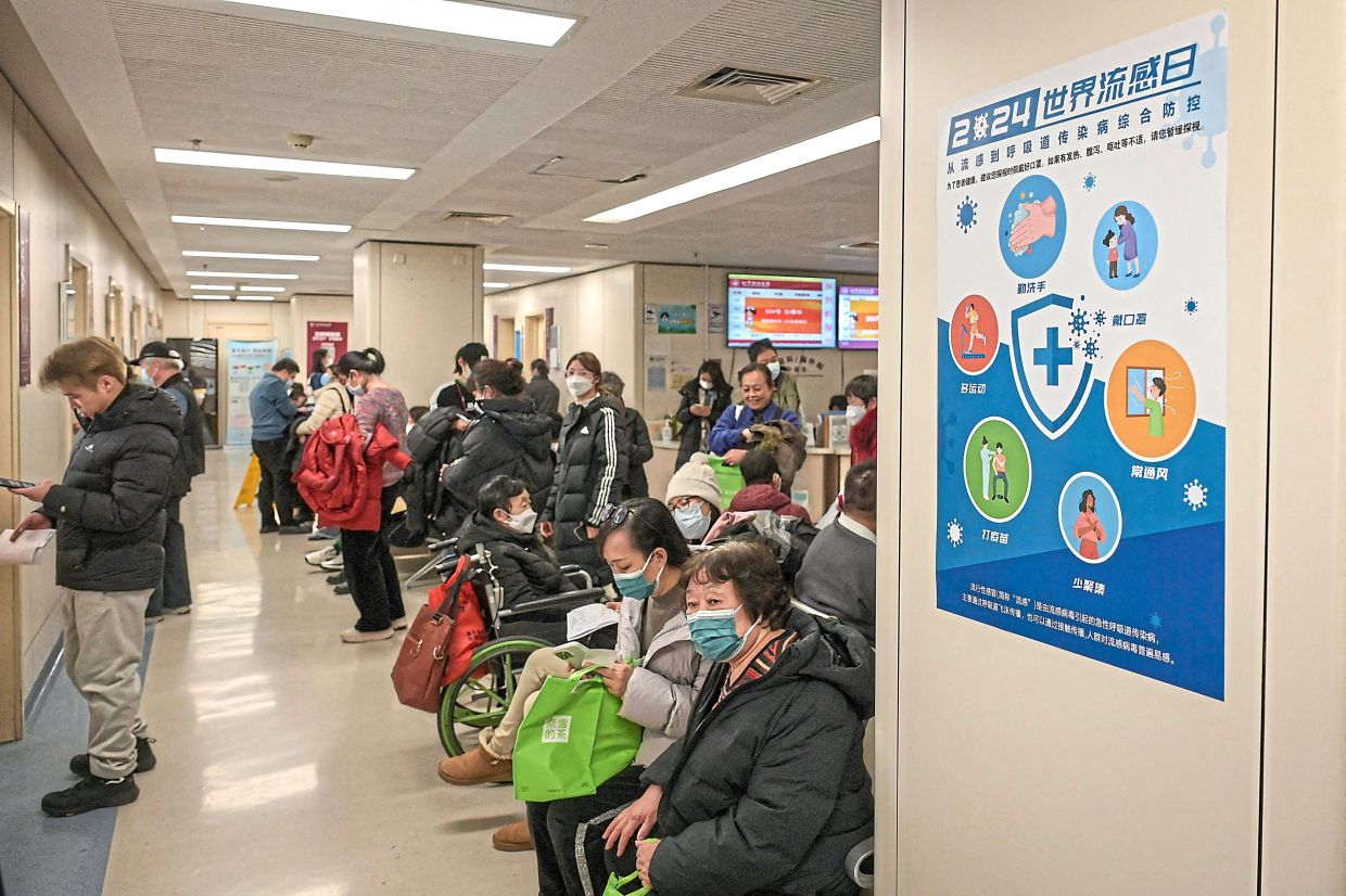 Staying safe: People wearing masks while waiting at an outpatient area of the respiratory department of a hospital in Beijing in this file photo from Jan 8. — AFP