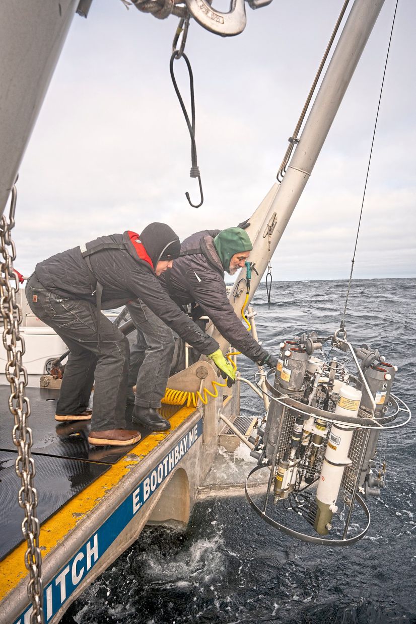 Fields (right) a zooplankton ecologist at the Bigelow Laboratory for Marine Sciences, helping to deploy a device for collecting water samples during a plankton-hunting mission off the coast of Maine. — Billy Hickey/The New York Times