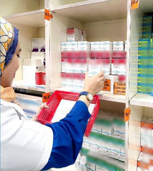 A pharmacist dispensing prescribed medicine according to patients’ needs, which will then be packed and sent via post for free. 