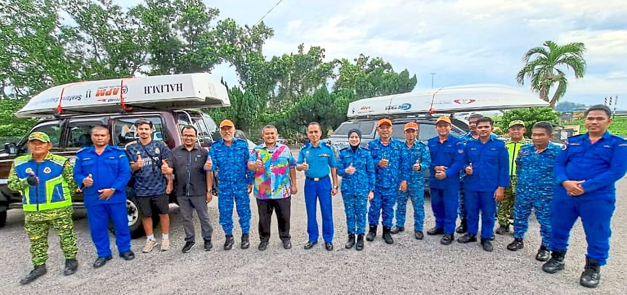 Always ready to serve: Lt-Kol (PA) Kamarulsyah (seventh from left), Assoc Kol (PA) Thien (fifth from left) and other members of the Melaka Civil Defence Force posing for a picture at a flood evacuation centre at SJK(C) Malim in Melaka.