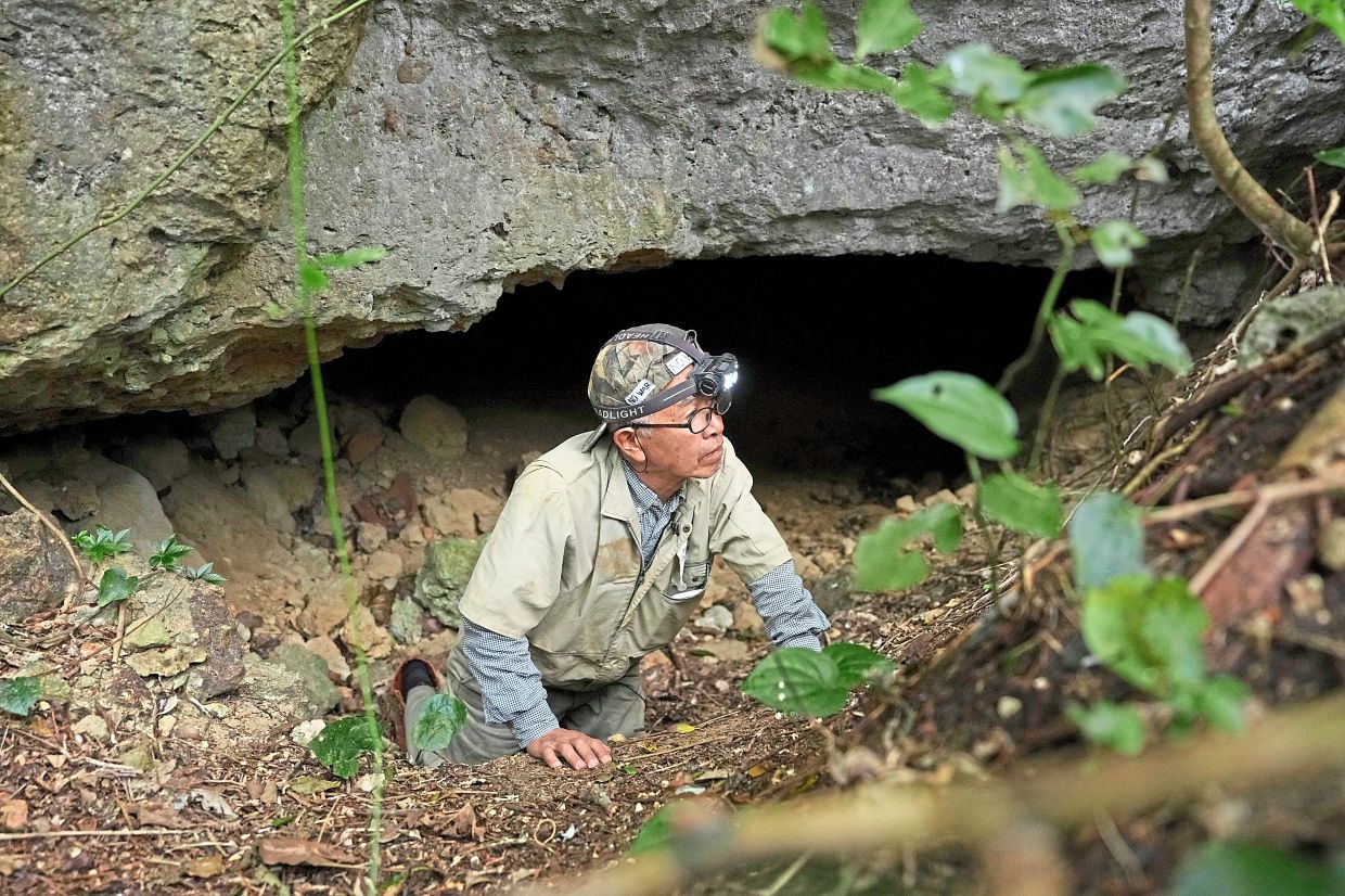 Takamatsu Gushiken leaves a cave after a session of searching for the remains of those who died during the Battle of Okinawa towards the end of the World War II in 1945.
