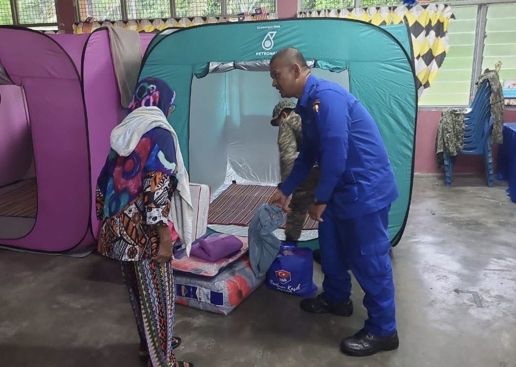 A flood evacuee was given assistance at the SK Seri Comel tenporary relief centre in Batu Pahat.