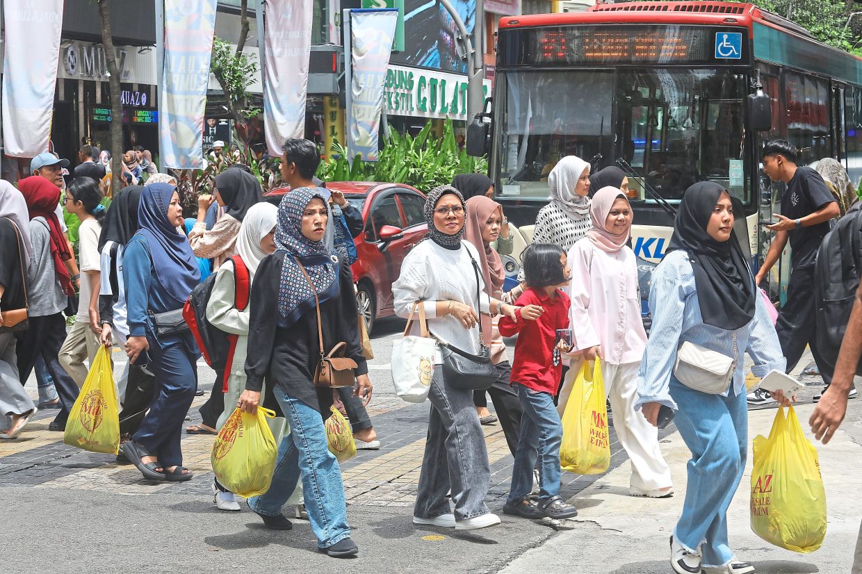 Shoppers carrying bags filled with their purchases making their way through Jalan Tuanku Abdul Rahman.