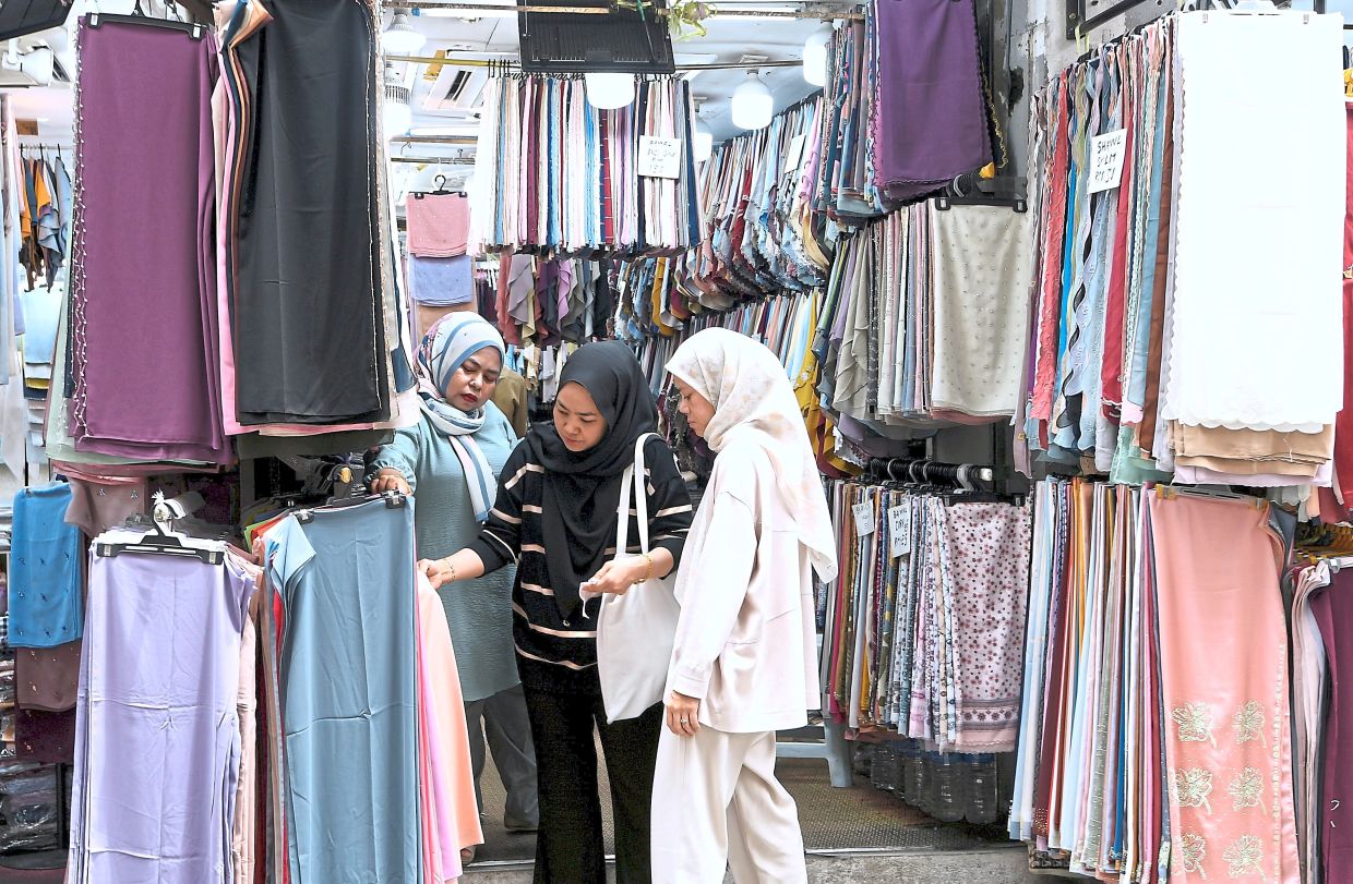 Women selecting headscarves at a stall at Jalan Masjid India.
