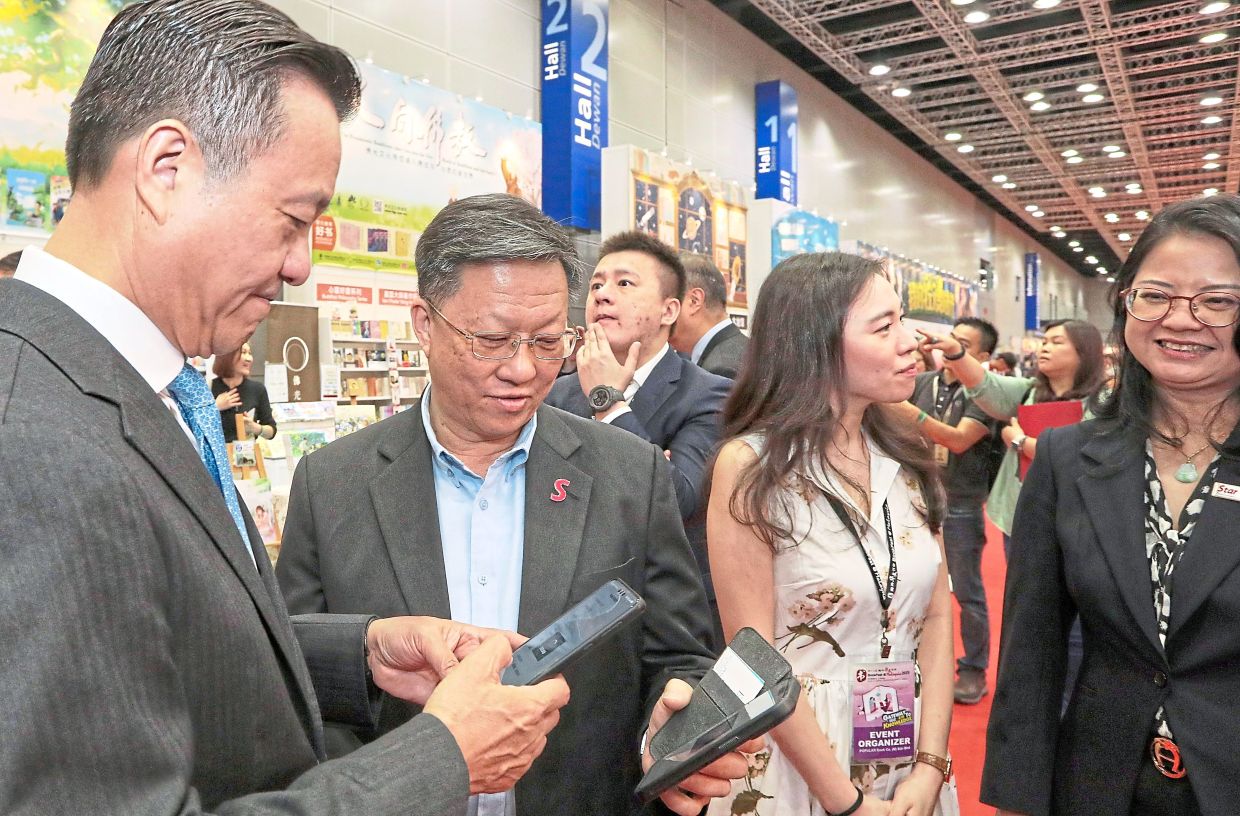 Making connections: Yiu (left) and Chan (second from left) exchanging contact details at BookFest @ Malaysia 2025, while Wang (right) speaks with Emily Yiu Nga Yu, chief executive officer of Popular Singapore. 