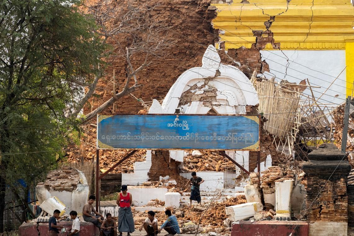 People sitting near a damaged pagoda on March 29, 2025. - Photo: Reuters