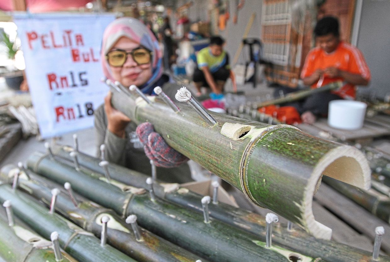 Hanafiza Hasnan inspecting her ‘pelita buluh’ before selling it to her customers. She runs the business from her house at Kampung Kechor in Kangar, Perlis.
