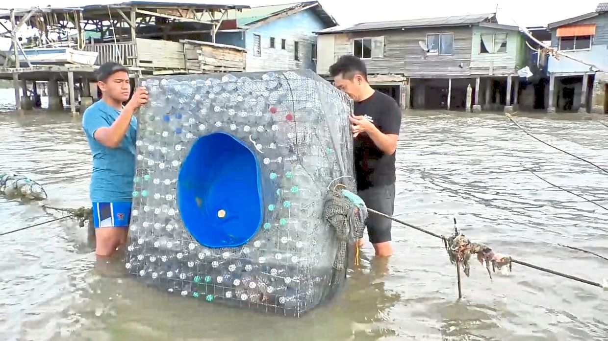 Volunteers installing a floating litter trap made from recycled plastic bottles and fishing nets.