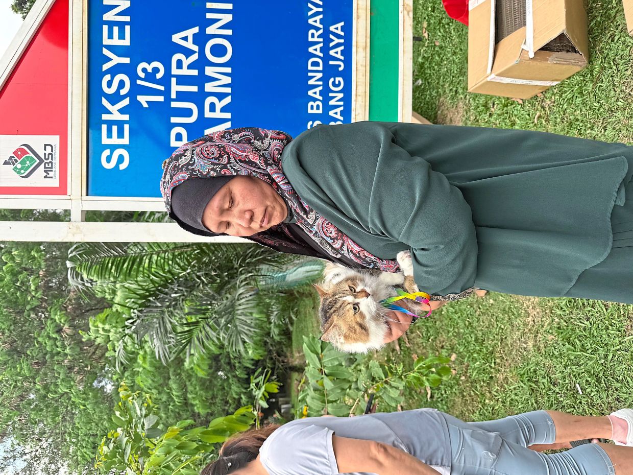 Fur family first: Yap Bee Pooi holding her beloved cat after rushing back to Putra Heights from Batu Pahat, Johor.