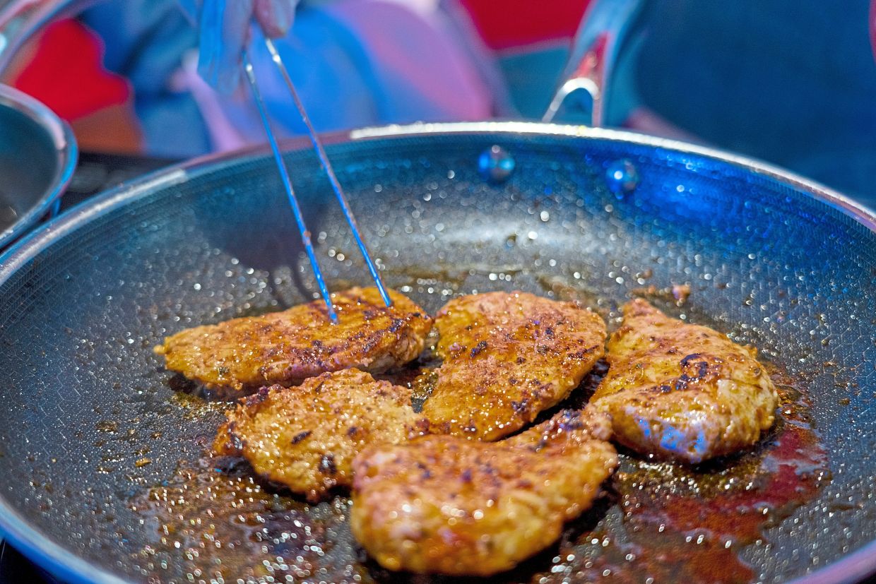 Lab-grown meat is prepared at an event held by Upside Foods in Miami, in June, last year. — Josh Ritchie/The New York Times