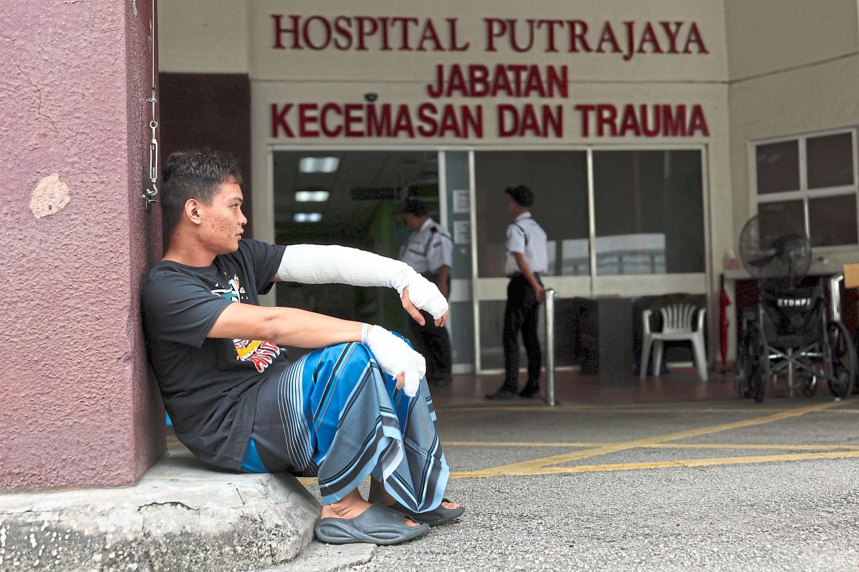 A moment to breathe: Fire victim Ahmad Daniel sitting outside Hospital Putrajaya after receiving treatment. — Bernama