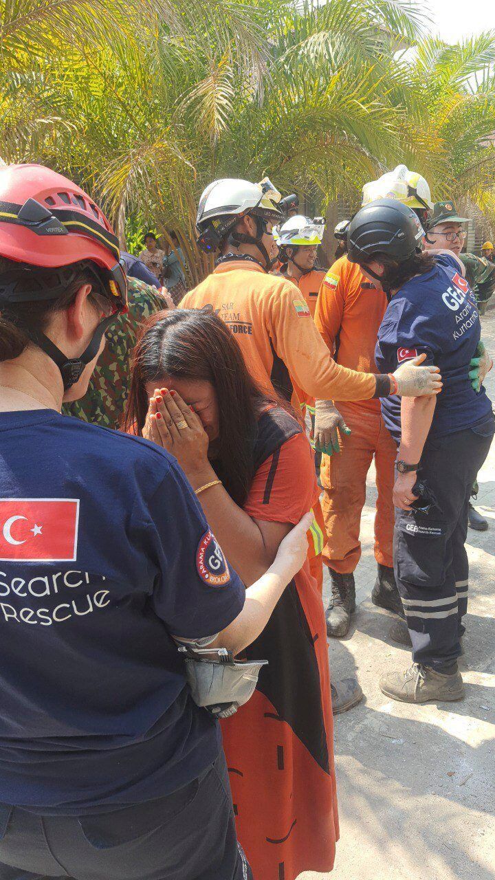 A family member of a rescued victim of the earthquake thanking rescuers from Turkey after they pulled two men out of a hotel in Naypyidaw on April 2 - AP