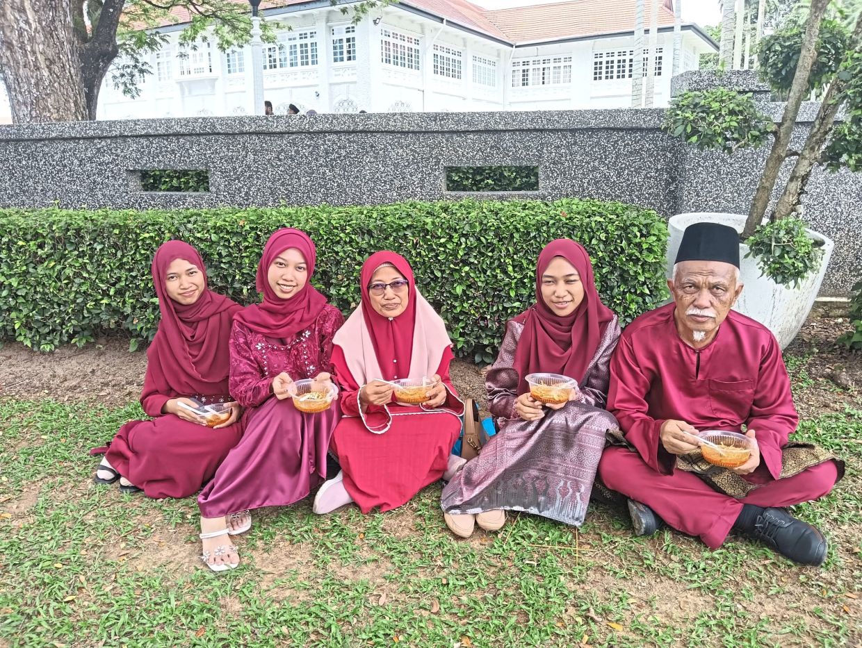 Azizah (centre) and her family at the event after having travelled from Simpang Renggam.