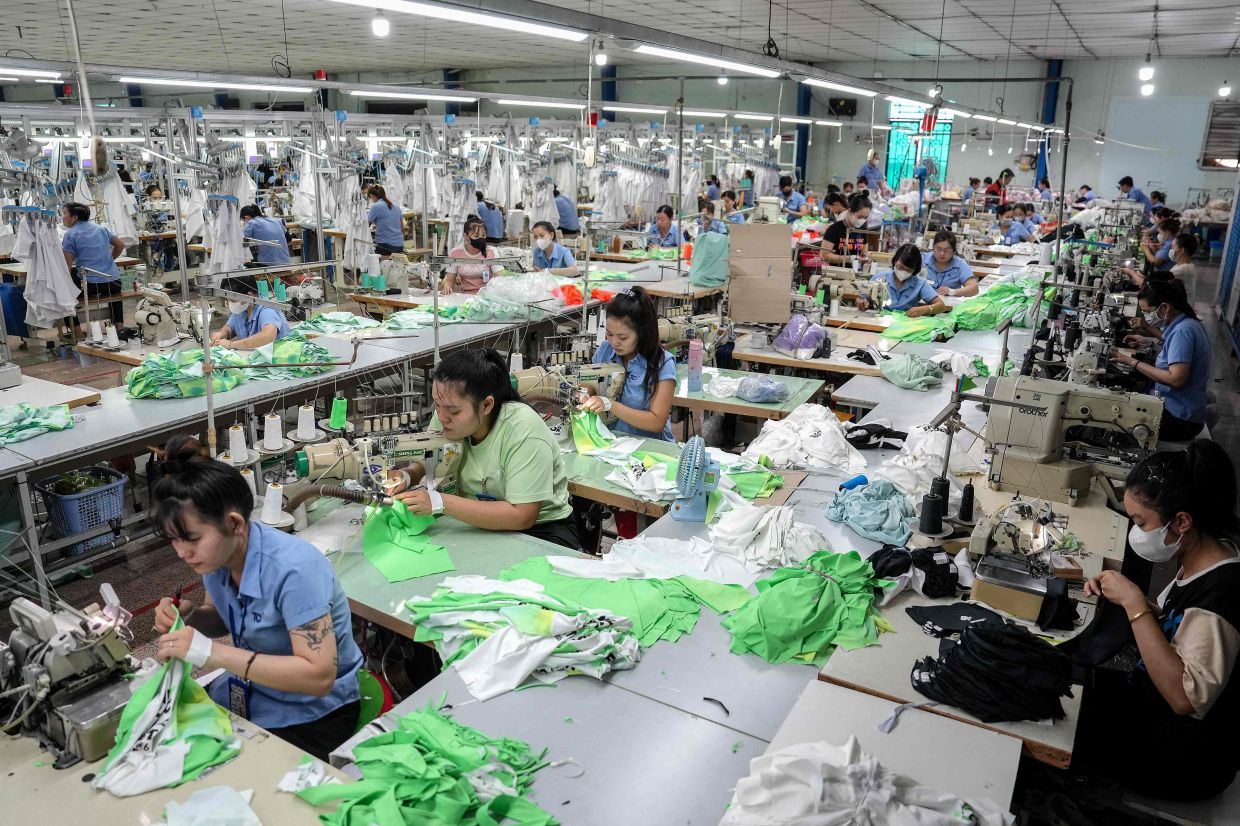 TOPSHOT - Vietnamese garment factory workers stitch apparel at a factory in Ho Chi Minh City after US President Donald Trump unveiled sweeping new tariffs on trading partners. At a garment factory in Ho Chi Minh City that exports T-shirts and underwear to the United States, staff are alarmed by shocking trade tariffs imposed on Vietnam that could severely impact their business. -- Photo by Huu Kha / AFP