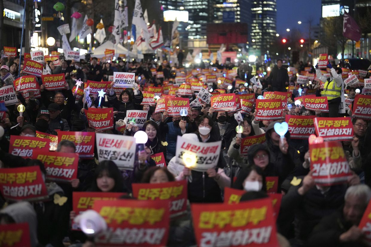 People shout slogans during a rally to celebrate after South Korea's Constitutional Court removed impeached South Korean President Yoon Suk Yeol from office, in Seoul, South Korea, Friday, April 4, 2025. The letters read -- Let's build a democratic government.-- AP Photo/Lee Jin-man