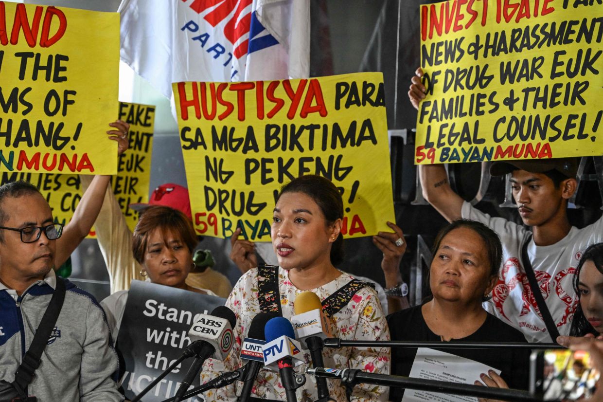 Supporters and family members of drug war victims raise placards after filing complaints at the Philippine National Bureau of Investigation (NBI) in Pasay, Metro Manila on Friday, April 4, 2025. Family members of people slain during the drug war and their lawyer filed a complaint to Philippine government investigators after receiving fierce online harassment since former president Rodrigo Duterte's arrest on charges of crimes against humanity. -- Photo by Jam STA ROSA / AFP