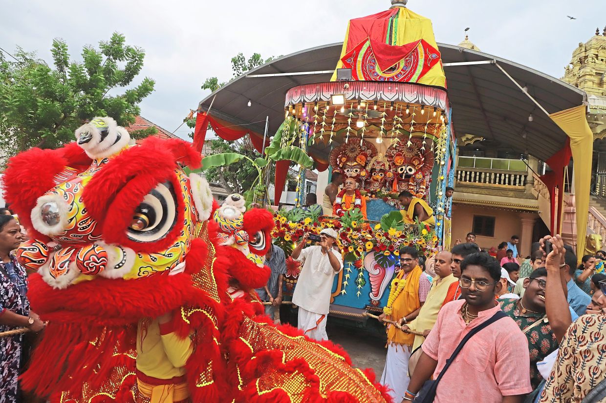 Sundarajoo (wearing garland) watching a lion dance.