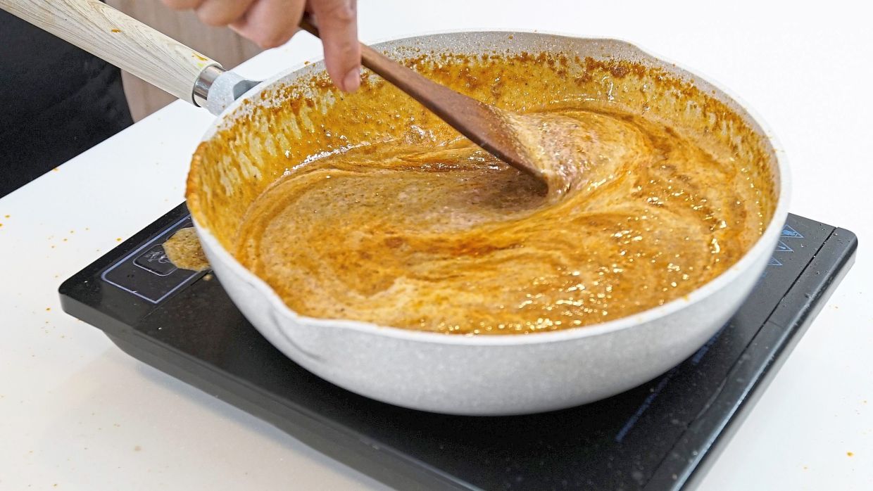 When the spices are sauteed until fragrant, deglaze the wok with fish stock, coconut milk and bring to a gentle simmer.