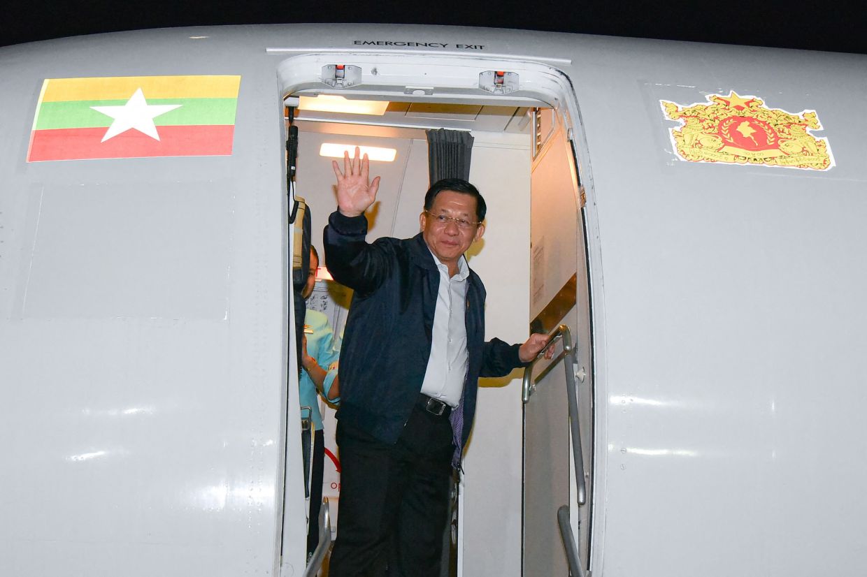 Myanmar's military chief Min Aung Hlaing waving from the door of his aircraft as he leaves Bangkok, after attending the 6th Bengal Initiative for Multi-Sectoral Technical and Economic Cooperation (BIMSTEC) summit in Bangkok. - AFP