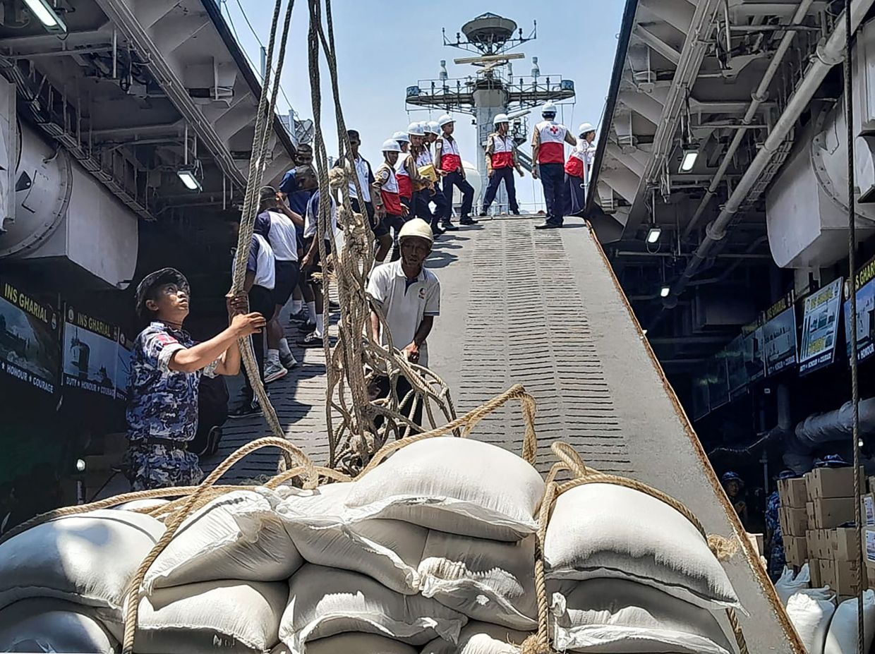 India's Ministry of External Affairs officers unloading sacks of aid donated by India to its earthquake-hit neighbour Myanmar upon its arrival at the Thilawa Port along the Yangon river. India's navy on Saturday, April 5, delivered hundreds of tonnes of food aid to Myanmar a day after Prime Minister Narendra Modi met the reclusive junta chief Min Aung Hlaing, following the devastating 7.7-magnitude quake on March 28. -- Photo by India's Ministry of External Affairs/ AFP