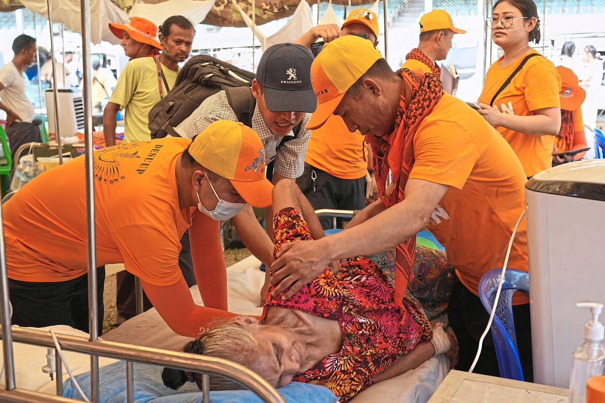 Bhutan medical volunteers treating a patient at their make-shift tent in Naypyidaw. — AP