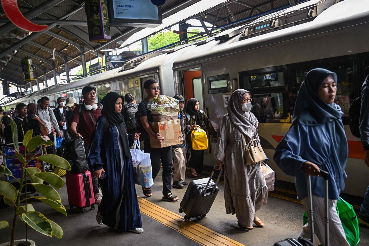 Passengers exit a train station upon their return in Surabaya on Sunday, April 6, 2025, after celebrating the Eid al-Fitr festival with families to mark the end of Ramadan. -- Photo by JUNI KRISWANTO / AFP