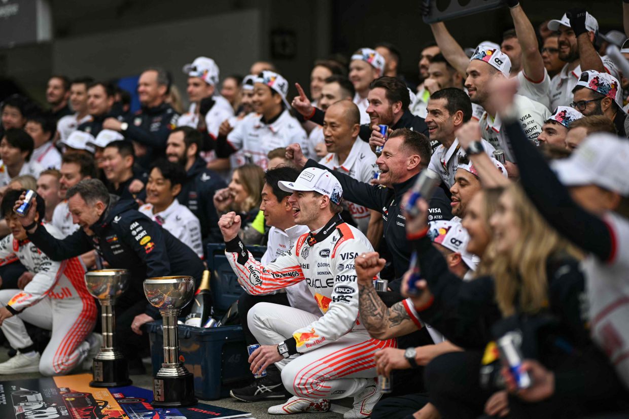 Red Bull Racing's Dutch driver Max Verstappen (centre) poses with team members as they celebrate his victory in the Formula One Japanese Grand Prix at the Suzuka circuit in Suzuka, Mie prefecture, Japan on Sunday, April 6, 2025. -- Photo by Philip FONG / AFP