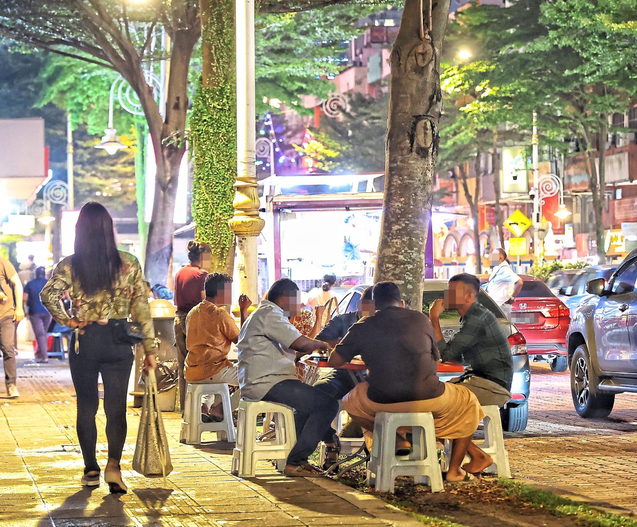 Diners enjoying their meal outdoors along a public walkway in Brickfields.