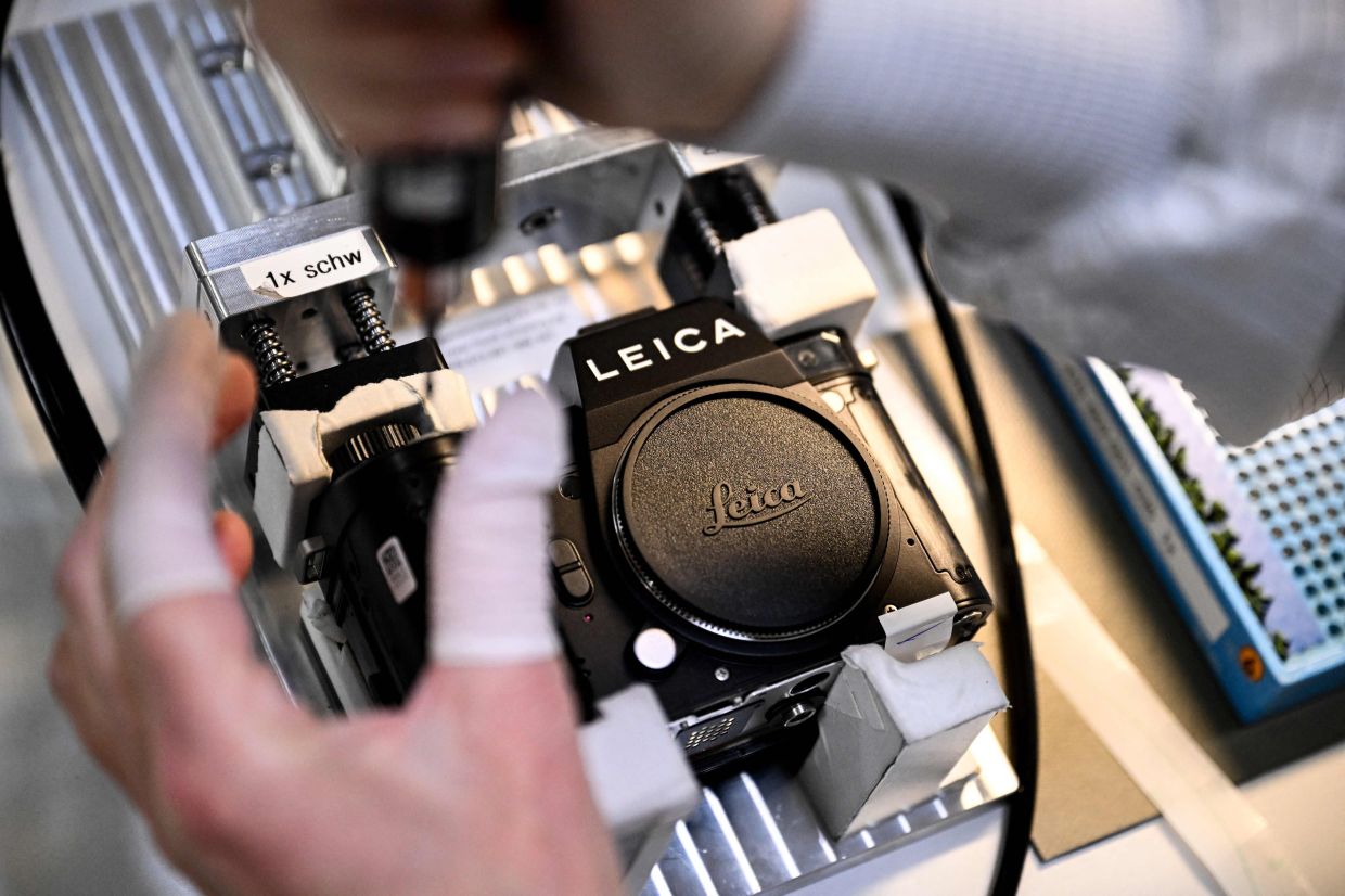 An employee assembles a Leica camera at the Leica factory in Wetzlar, western Germany. — AFP