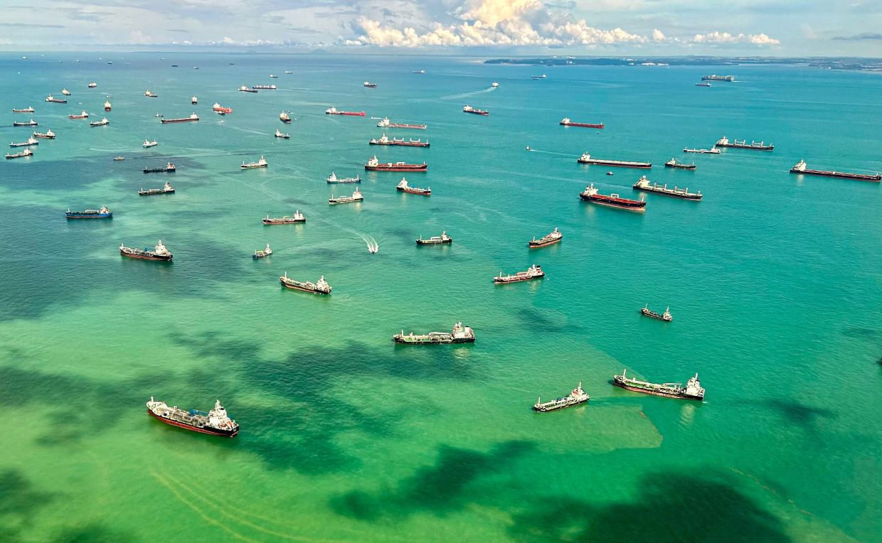 This aerial view taken from a commercial flight shows cargo ships docked along the strait in Singapore on Monday, April 7, 2025. -- Photo by Mohd RASFAN / AFP