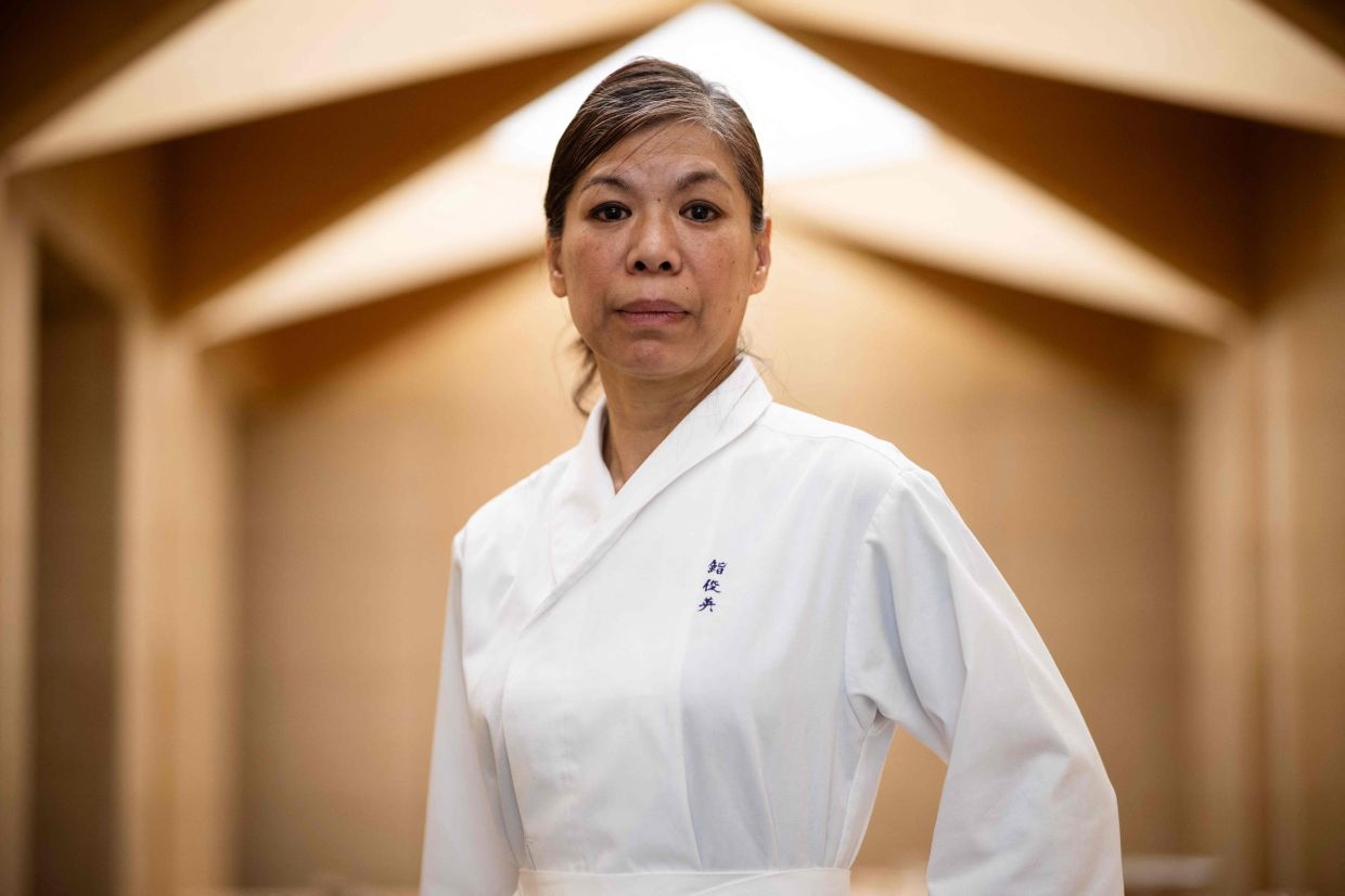 Japan's Chizuko Kimura, the first woman in the world to be awarded a star by the Guide Michelin as a sushi chef, poses during a photo session at her restaurant Sushi Shunei in Paris, on Monday, April 7, 2025. -- Photo by JULIEN DE ROSA / AFP