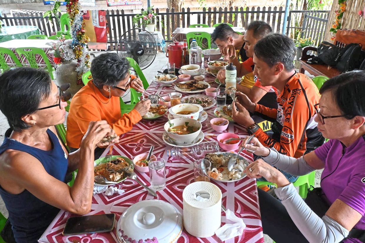 Cyclists having a sumptuous lunch break after covering a distance of 96km from Songkhla to Ranot.