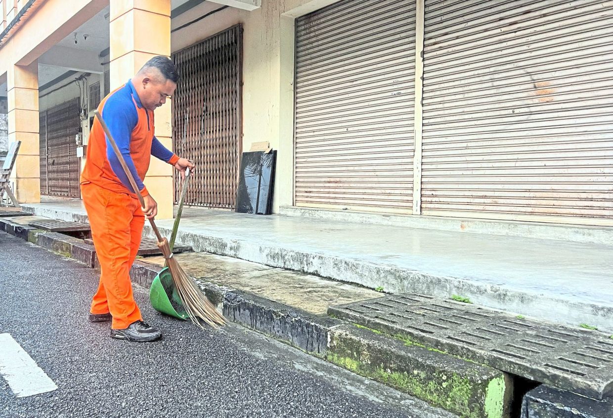 Raihan keeping the streets of Pekan Nenas clean during the festive period.