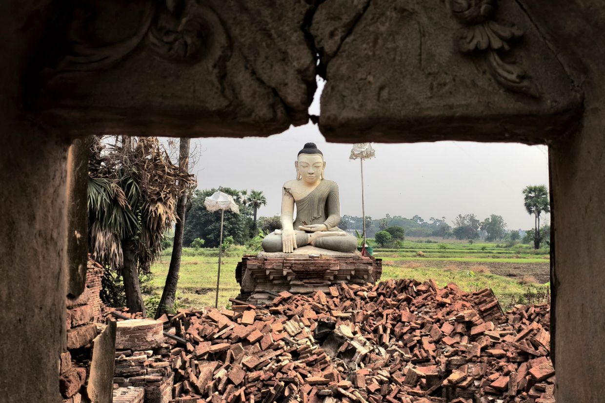 A Buddha statue is surrounded by debris in Inn Wa on the outskirts of Mandalay on April 6, 2025, following the devastating March 28 earthquake. - AFP