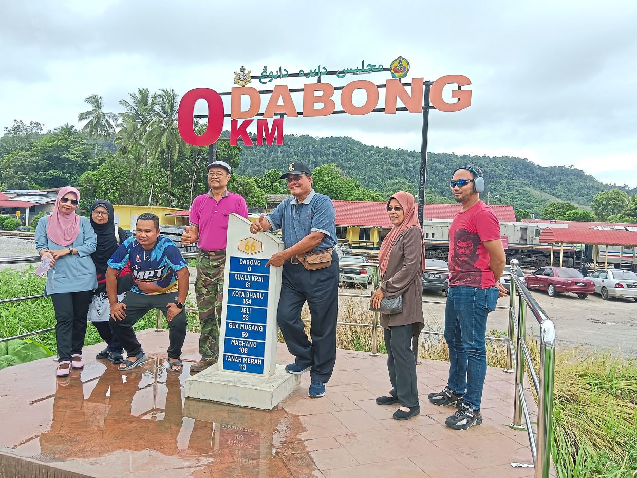 Above: (From left) Maznah and Siji Ajar, with (from right) Emirin, Zakiah and other passengers during their tour.Left: Drone shot of JNK5 stopped in Dabong.