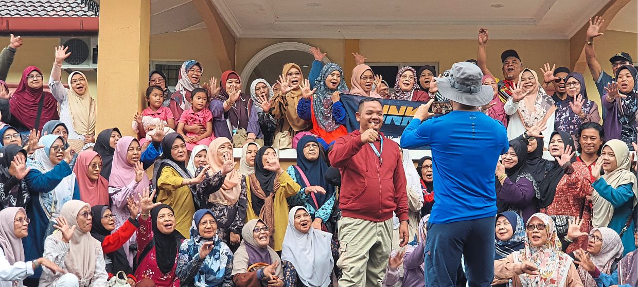 Hassin (standing, front) in a group shot with passengers of JNK5 at the Wakaf Bharu station in Kelantan.
