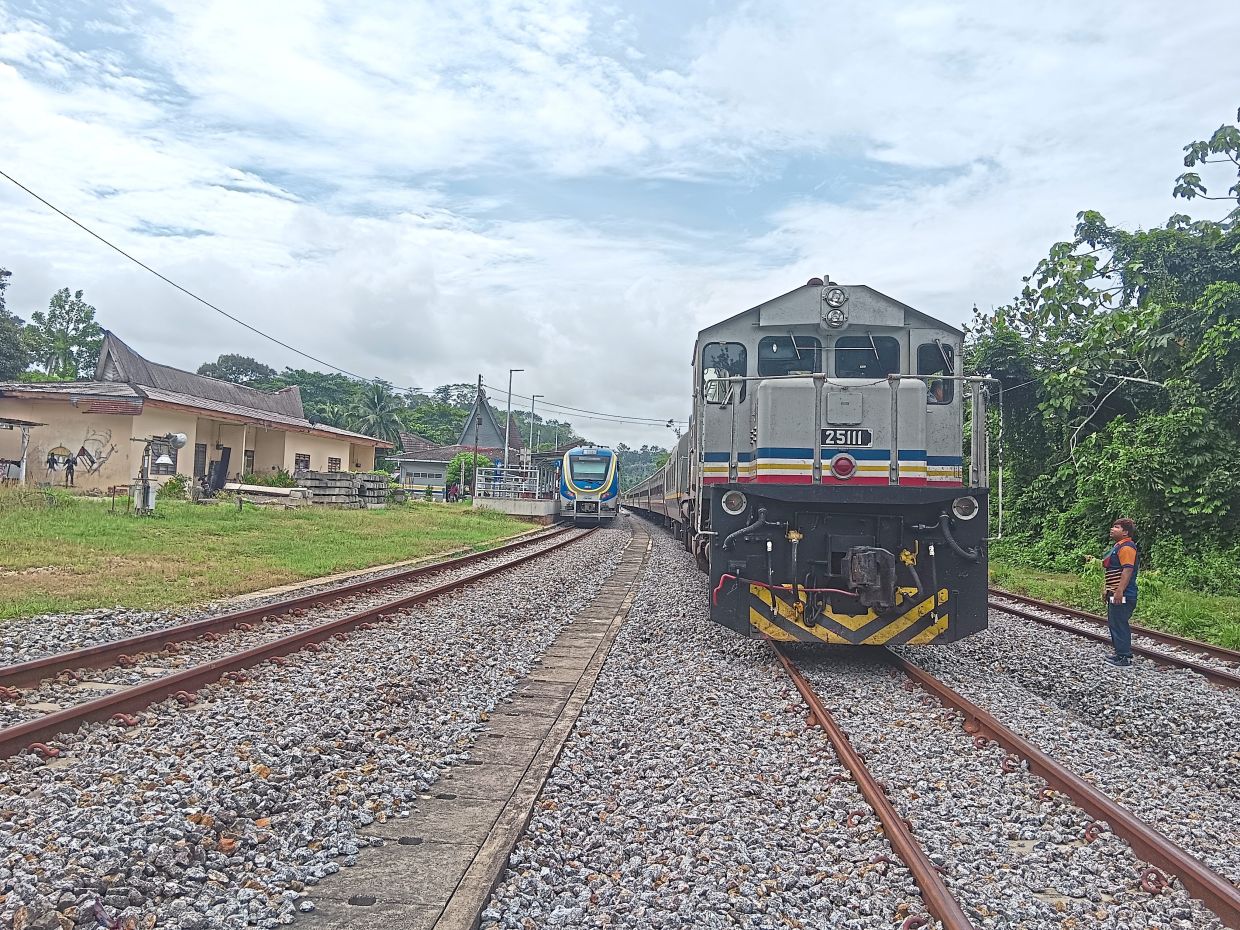 JNK5 train pulled by locomotive 25111 Pulau Redang (right) stops in Ulu Temiang, Kelantan, to allow a modern KTM Intercity Shuttle Timuran service (left) to pass. — Photos: EZANOR MK and FAIHAN GHANI/The Star and courtesy photos