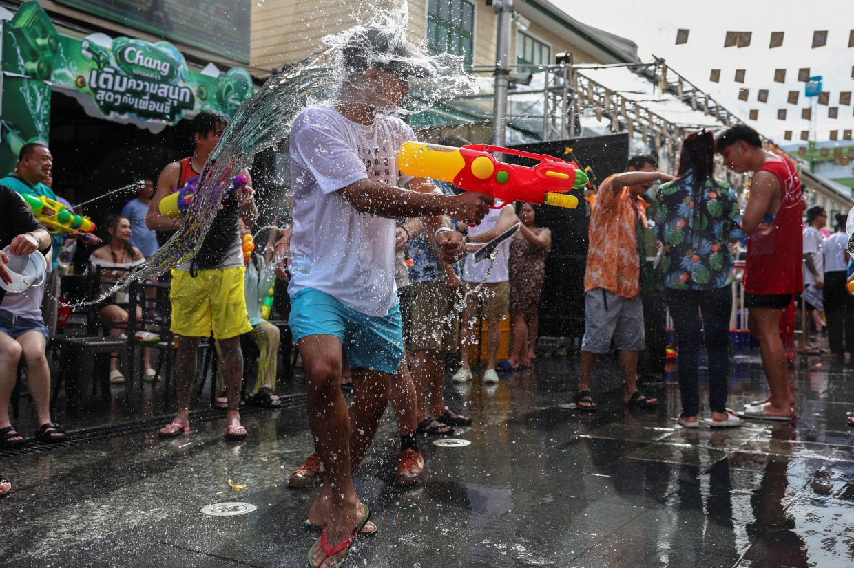 Revellers play with water as they celebrate the Songkran holiday, which marks the Thai New Year, in Bangkok, Thailand, on Saturday, April 12, 2025. -- REUTERS/Chalinee Thirasupa