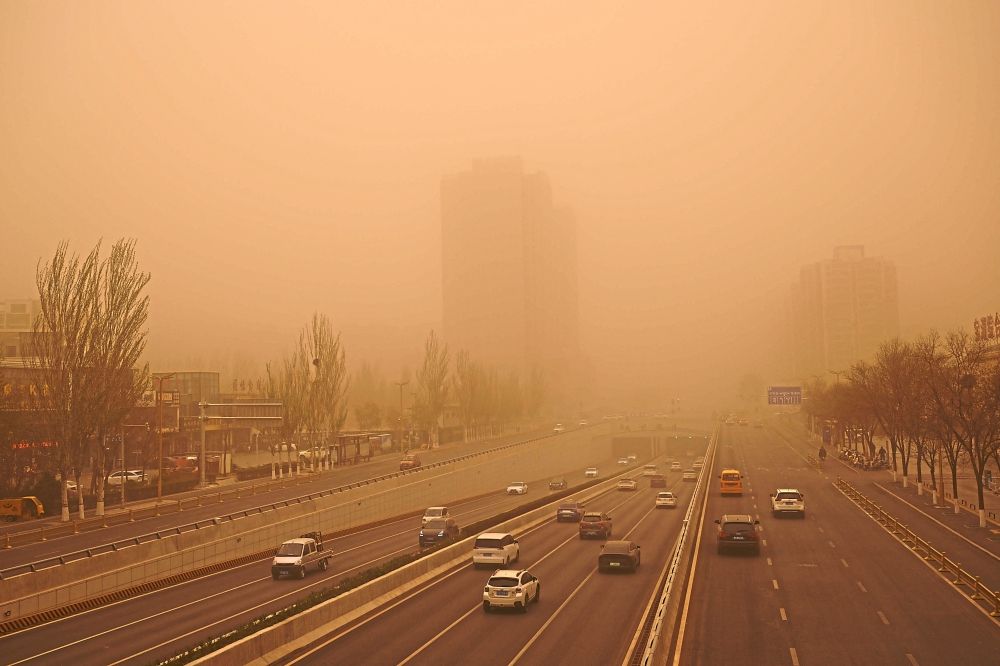 Dust gets inyour eyes:Motoristscommutingduring asandstorm inYinchuan,Ningxiaregion.— AFP