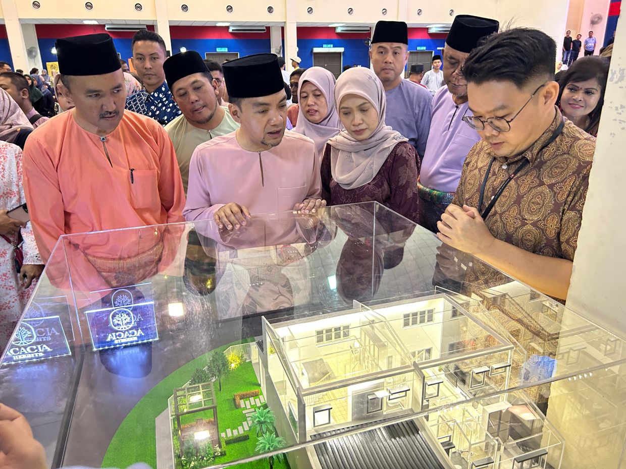 Johor Mentri Besar Datuk Onn Hafiz Ghazi (second left) together with Johor housing and local government committee chairman Datuk Mohd Jafni Md Shukor (left) and Johor Housing Development Corporation's (PKPJ) chief executive officer Datin Paduka Dr Suhailizan Suliman (second right) looking at a housing model after the J-Home One-Stop Centre (OSC) and RMMJ certificate handover programme at Dewan Muafakat, Simpang Renggam District Council, Kluang.