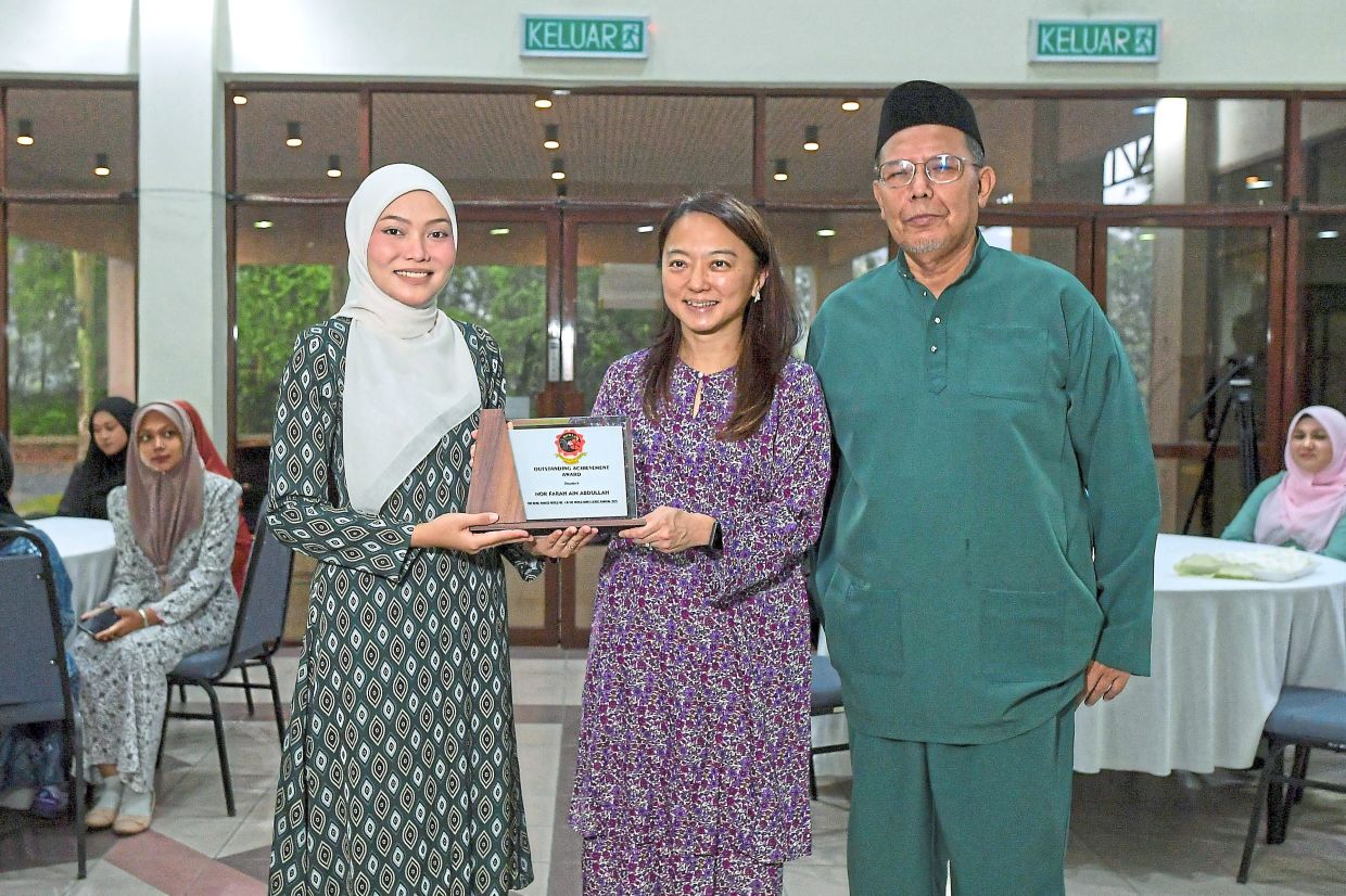 Nor Farah receiving the Outstanding Achievement Award from Sports Minister Hannah Yeoh. On the right is Farah’s coach Zuraidi Puteh. — Bernama