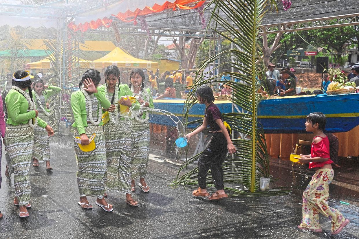 Women are sprayed with water during the first day of annual water festival. —AP