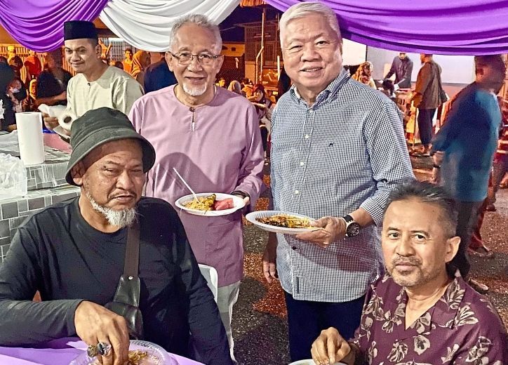 Wong (standing, right) catching up with Mohd Nasir (standing, left) and other friends at the Aidilfitri celebration in Ajil. — Courtesy photos